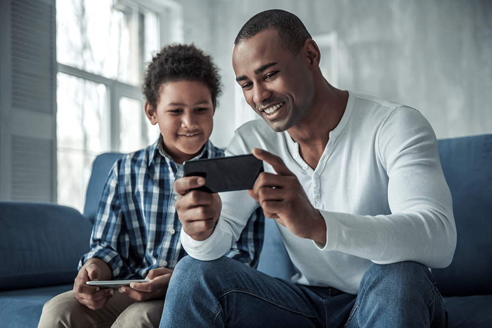 father and son watching livestream on their phone