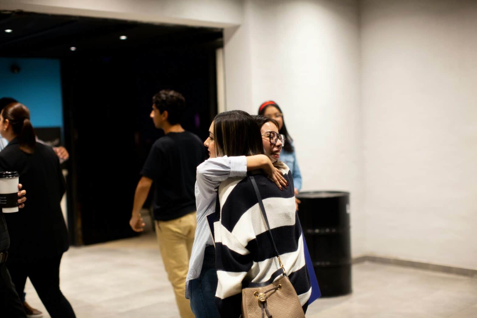 friends giving each other a hug in a church lobby