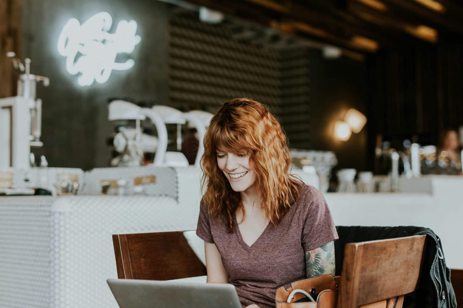 woman in coffee shop watching something on laptop