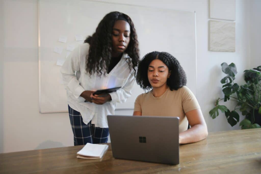 two women looking at and evaluating something on a laptop