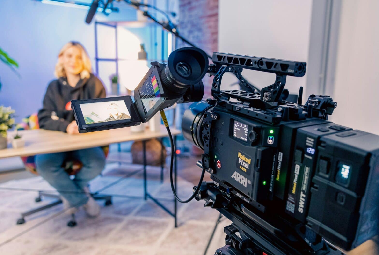 woman sitting behind a desk being livestreamed